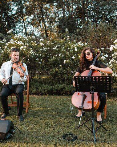 Violinista y violonchelista de Tempo Urbano tocando en un jardín